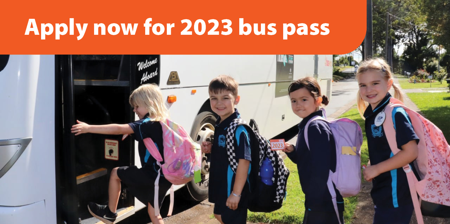 school kids entering a bus, holding up their bus passes